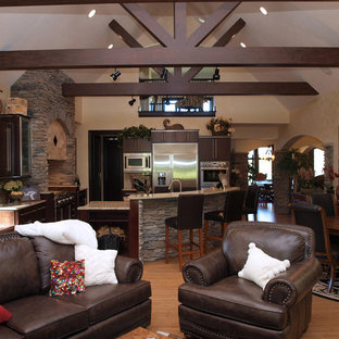 Diseño de salón abierto, de estilo americano, grande, con paredes beige y suelo de madera clara