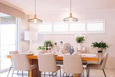 Photo of a mid-sized transitional dining room in Sydney with white walls and porcelain floors.