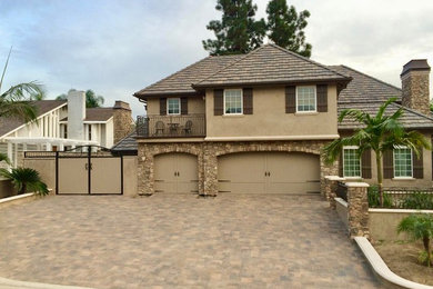 This is an example of a mid-sized traditional full sun front yard driveway in Orange County.