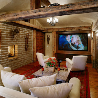 Inspiration for an enclosed home cinema in Santa Barbara with medium hardwood flooring, a built-in media unit and orange floors.