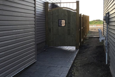 Mid-sized elegant side yard tile patio photo in Calgary with no cover