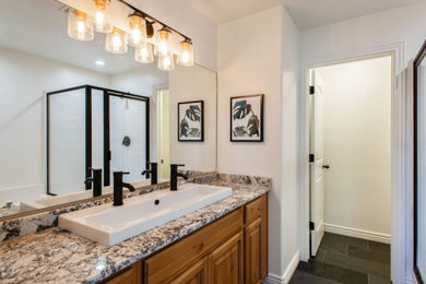 Inspiration for a mid-sized transitional master slate floor, gray floor and double-sink toilet room remodel in Salt Lake City with medium tone wood cabinets, white walls, a vessel sink, granite countertops, multicolored countertops and a built-in vanity
