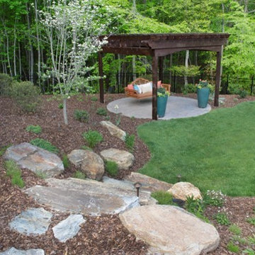 Boulder steps leading to cedar pergola and daybed swing.