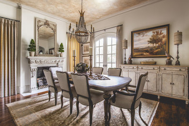 Large tuscan medium tone wood floor enclosed dining room photo in Dallas with white walls and a standard fireplace