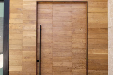 Esempio di una grande porta d'ingresso con pavimento alla veneziana, una porta a pivot e una porta in legno chiaro
