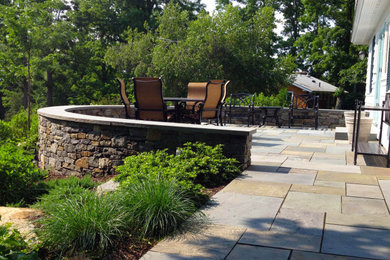 Inspiration for a large timeless backyard stone patio remodel in Providence with no cover