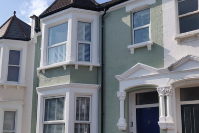 ロンドンにあるラグジュアリーな中くらいなヴィクトリアン調のおしゃれな二階建ての家 (塗装レンガ) の写真