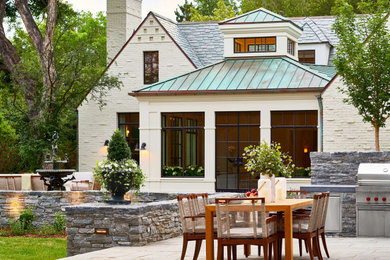 デンバーにある巨大なトランジショナルスタイルのおしゃれな裏庭のテラス (アウトドアキッチン、天然石敷き、日よけなし) の写真