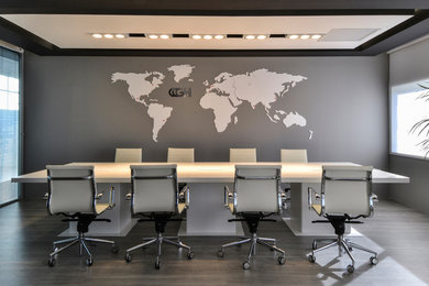 Diseño de despacho minimalista de tamaño medio con paredes grises y suelo de madera en tonos medios