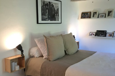 Aménagement d'une grande chambre parentale classique avec un mur blanc, tomettes au sol et un sol multicolore.