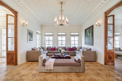 Living room - large traditional enclosed and formal medium tone wood floor and brown floor living room idea in New York with beige walls, a corner fireplace, a stone fireplace and no tv
