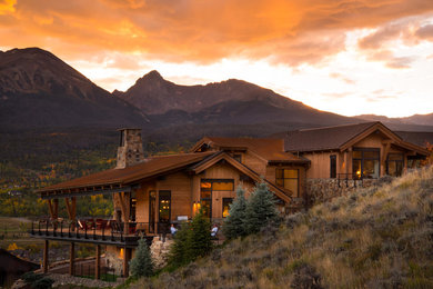 Example of a large mountain style brown two-story wood gable roof design in Denver