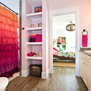 Immagine di una stanza da bagno per bambini moderna di medie dimensioni con ante con riquadro incassato, ante in legno chiaro, pareti rosa, parquet scuro, lavabo da incasso, top in laminato, pavimento marrone e top marrone