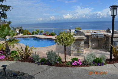 Inspiration for a large transitional backyard stamped concrete patio fountain remodel in Vancouver with no cover