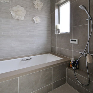 Esempio di una stanza da bagno moderna con vasca ad angolo, doccia aperta, pareti grigie, pavimento grigio e doccia aperta