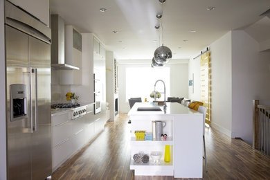 Inspiration for a large contemporary u-shaped eat-in kitchen remodel in Calgary with flat-panel cabinets, white cabinets, laminate countertops, white backsplash, porcelain backsplash and an island