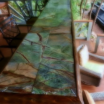 Two level deck on slope in the woods; custom bar using rainforest marble