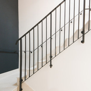 Design ideas for a large modern u-shaped metal railing staircase in Kent with limestone treads and limestone risers.