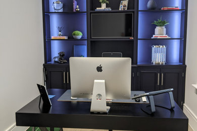 Ejemplo de despacho minimalista pequeño con suelo de madera en tonos medios y escritorio independiente