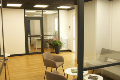 Réalisation d'un bureau design de taille moyenne avec un mur blanc, parquet clair et un sol beige.