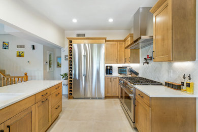 Example of a mid-sized transitional l-shaped porcelain tile and beige floor eat-in kitchen design in Other with a double-bowl sink, flat-panel cabinets, beige cabinets, quartz countertops, white backsplash, porcelain backsplash, stainless steel appliances, a peninsula and white countertops