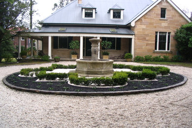 Inspiration for a traditional front yard driveway in Sydney with a water feature.