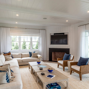 Maritimes Wohnzimmer mit weißer Wandfarbe, hellem Holzboden, Kamin, Wand-TV und beigem Boden in New York