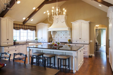 Large traditional u-shaped eat-in kitchen in Chicago with a farmhouse sink, recessed-panel cabinets, white cabinets, solid surface benchtops, white splashback, porcelain splashback, stainless steel appliances, dark hardwood floors, with island and brown floor.