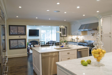 Example of a large classic u-shaped dark wood floor and brown floor enclosed kitchen design in St Louis with an undermount sink, beaded inset cabinets, white cabinets, quartzite countertops, stone slab backsplash, paneled appliances and two islands