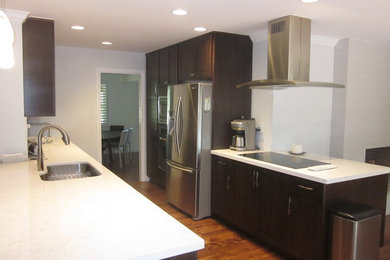 Example of a mid-sized transitional galley medium tone wood floor and brown floor eat-in kitchen design in San Francisco with an undermount sink, shaker cabinets, dark wood cabinets, quartz countertops, white backsplash, marble backsplash, stainless steel appliances, a peninsula and white countertops