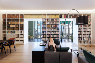Imagen de sala de estar con biblioteca abierta contemporánea extra grande con suelo de madera clara