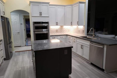 Kitchen - kitchen idea in Other with an undermount sink, glass tile backsplash and an island