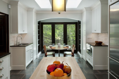 Example of a trendy kitchen design in Minneapolis with stainless steel appliances and wood countertops