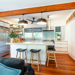 Photo of a mid-sized contemporary u-shaped open plan kitchen in Sunshine Coast with an integrated sink, flat-panel cabinets, white cabinets, laminate benchtops, blue splashback, with island, multi-coloured benchtop, stainless steel appliances, medium hardwood floors and brown floor.