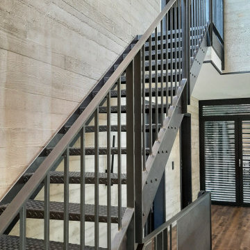 Treppen und Geländer zu hohen Sichtbetonwänden