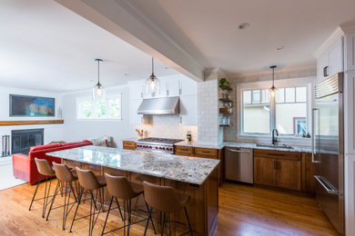 Inspiration for a mid-sized timeless medium tone wood floor and brown floor open concept kitchen remodel in Cincinnati with an undermount sink, recessed-panel cabinets, medium tone wood cabinets, white backsplash, ceramic backsplash, stainless steel appliances and an island
