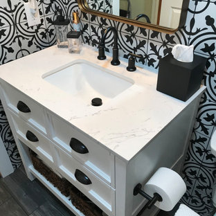 Bild på ett litet vintage vit vitt en-suite badrum, med skåp i shakerstil, vita skåp, ett badkar i en alkov, en dusch i en alkov, en toalettstol med separat cisternkåpa, svart och vit kakel, keramikplattor, vita väggar, ett undermonterad handfat, bänkskiva i kvartsit, svart golv och dusch med skjutdörr