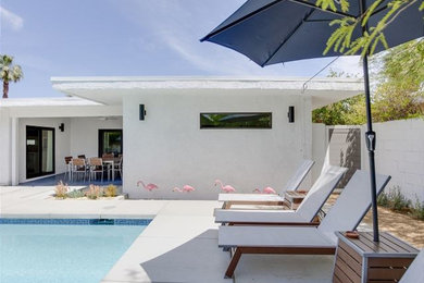 Example of a 1960s white one-story stucco exterior home design in Other