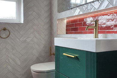 Example of a mid-sized trendy master white tile and porcelain tile porcelain tile, black floor and single-sink bathroom design in Dublin with furniture-like cabinets, green cabinets, a wall-mount toilet, red walls, a drop-in sink and a floating vanity