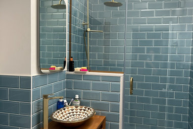 Doorless shower - mid-sized contemporary blue tile and ceramic tile ceramic tile, white floor and single-sink doorless shower idea in Dublin with louvered cabinets, medium tone wood cabinets, a one-piece toilet, white walls, a vessel sink, wood countertops, a hinged shower door, brown countertops and a freestanding vanity