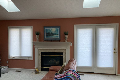 Foto de sala de estar abierta y abovedada contemporánea grande con todas las chimeneas, marco de chimenea de piedra, televisor colgado en la pared y suelo beige
