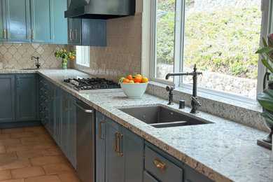 Example of a terra-cotta tile and beige floor kitchen design with a double-bowl sink, blue cabinets, white backsplash and ceramic backsplash