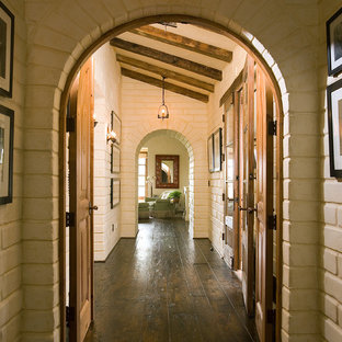 Inspiration för mellanstora amerikanska hallar, med mörkt trägolv, vita väggar och brunt golv