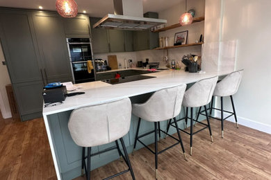 Design ideas for a large modern u-shaped kitchen/diner in London with a single-bowl sink, green cabinets, marble worktops, white splashback, ceramic flooring, an island, brown floors and yellow worktops.