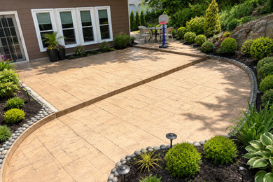 Example of a mid-sized backyard stamped concrete patio design in Atlanta with no cover