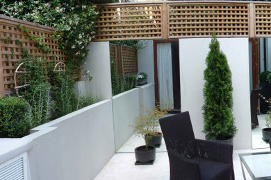 Aménagement d'une terrasse arrière classique avec des pavés en pierre naturelle.