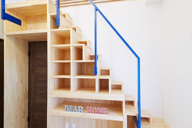 Photo of a mid-sized modern wood u-shaped staircase in Other with wood risers and metal railing.