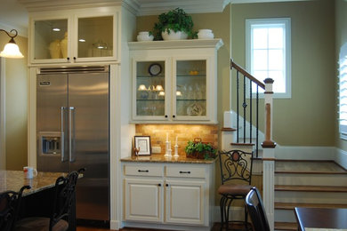 Mid-sized medium tone wood floor open concept kitchen photo in Charlotte with an undermount sink, white cabinets, granite countertops, beige backsplash, stainless steel appliances and an island