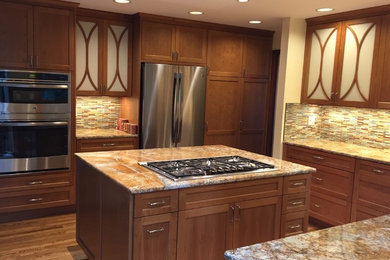 Eat-in kitchen - mid-sized eclectic u-shaped medium tone wood floor and brown floor eat-in kitchen idea in Seattle with an undermount sink, shaker cabinets, medium tone wood cabinets, granite countertops, multicolored backsplash, stainless steel appliances, an island and mosaic tile backsplash