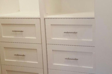 Walk-in closet - large modern gender-neutral porcelain tile walk-in closet idea in Calgary with shaker cabinets and white cabinets